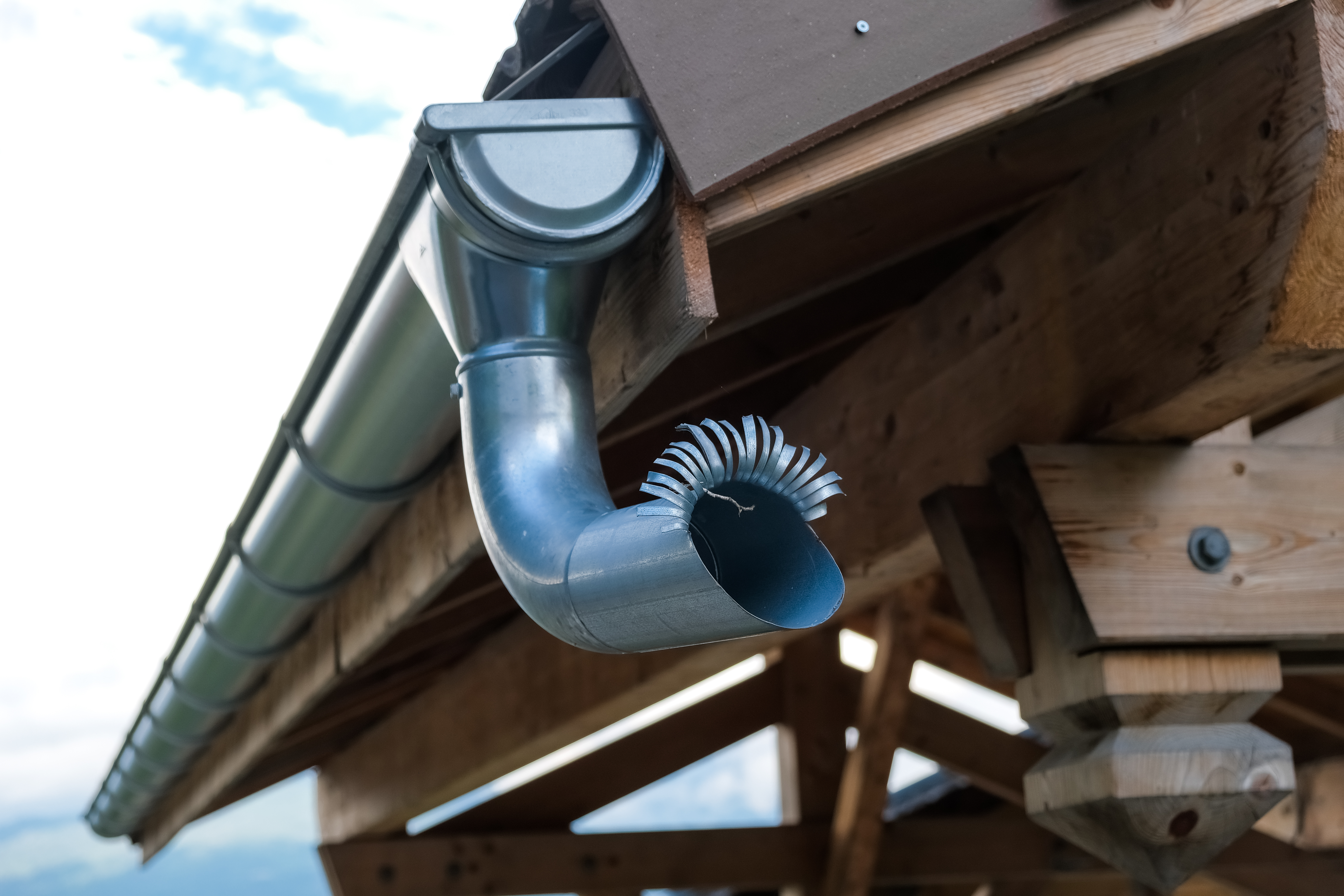 Image of side view of a metal drainpipe from the roof of a house